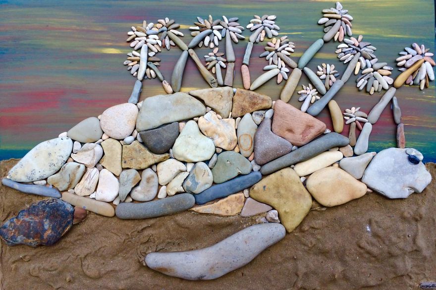 artwork made of stones coming out of the sea