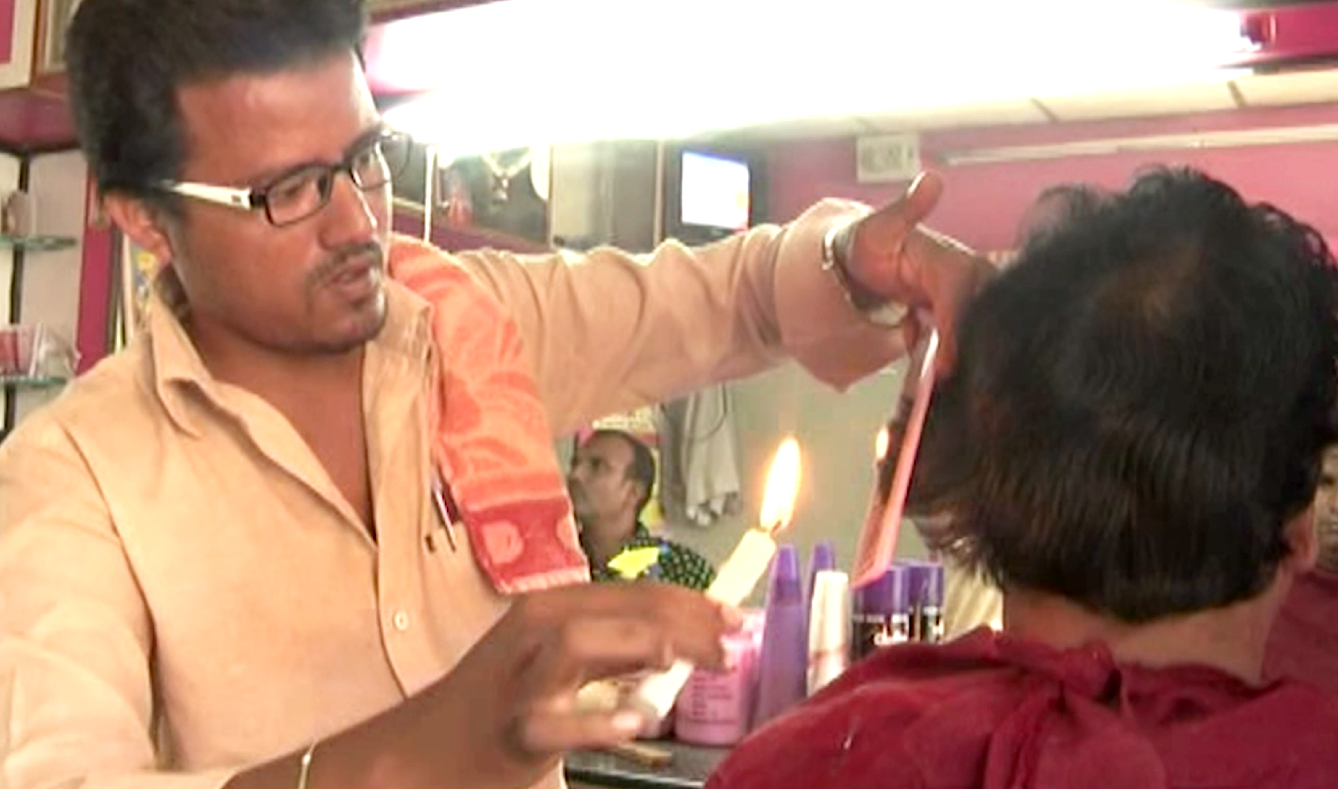 Here in this salon, barber uses candles for haircuts