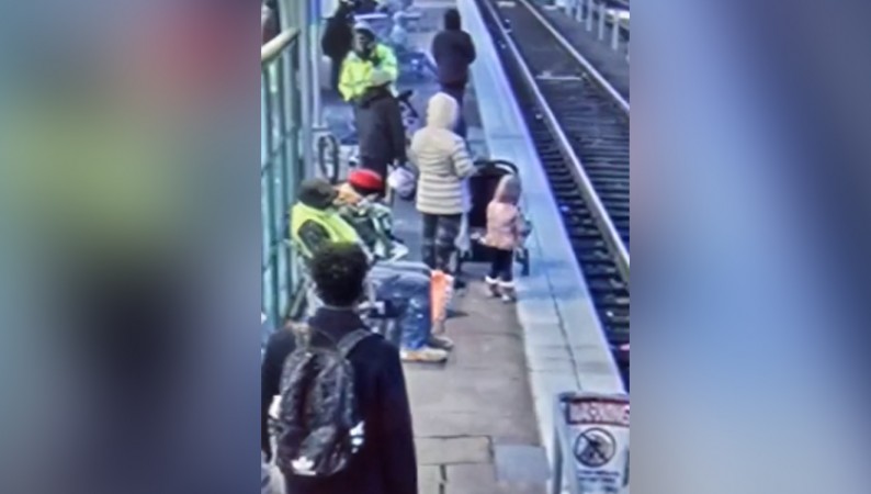 Passengers were waiting for the train on the platform, then the woman pushed the child